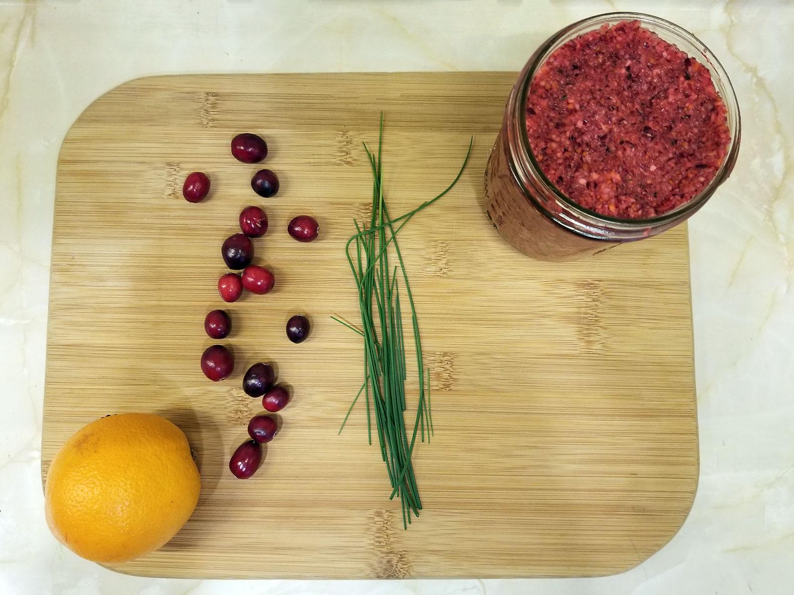 Ingredients for wild onion cranberry relish arranged on a cutting board