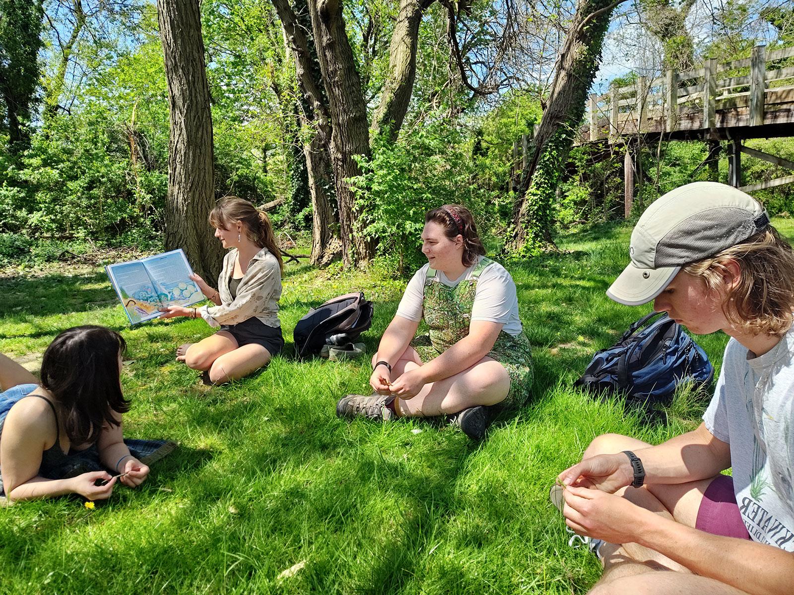 Permaculture Interns reading a book on plant patterns